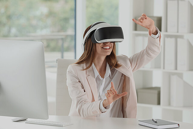 Eine Frau im Büro probiert eine neue Technologie mit VR Brille.