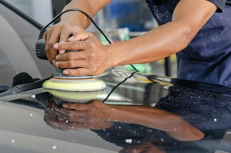 Ein Handwerker entfernt einen Autokratzer.