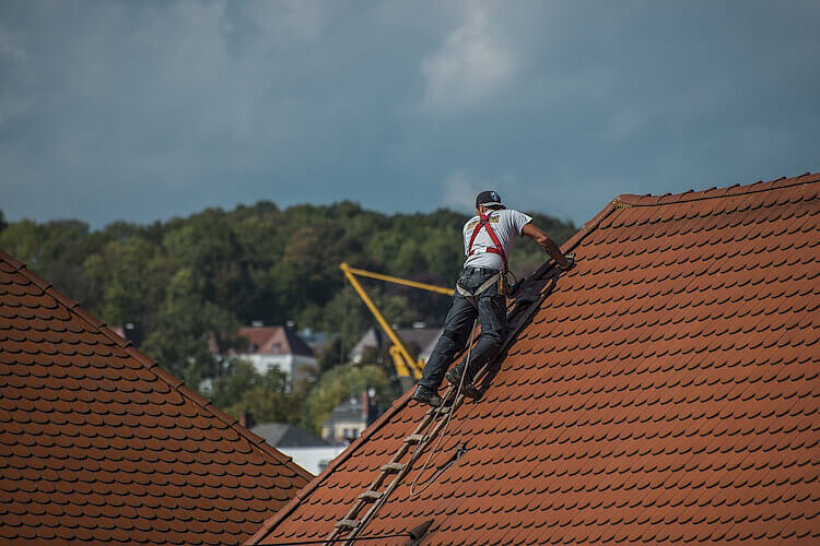 Ein Handwerker dichtet ein Bauwerk ab.