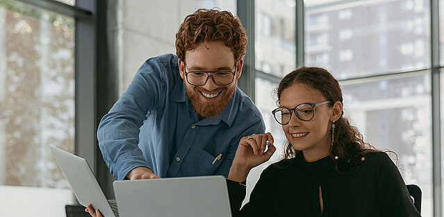 Zwei Personen kaufen am Laptop Firmendaten von FirmenABC.