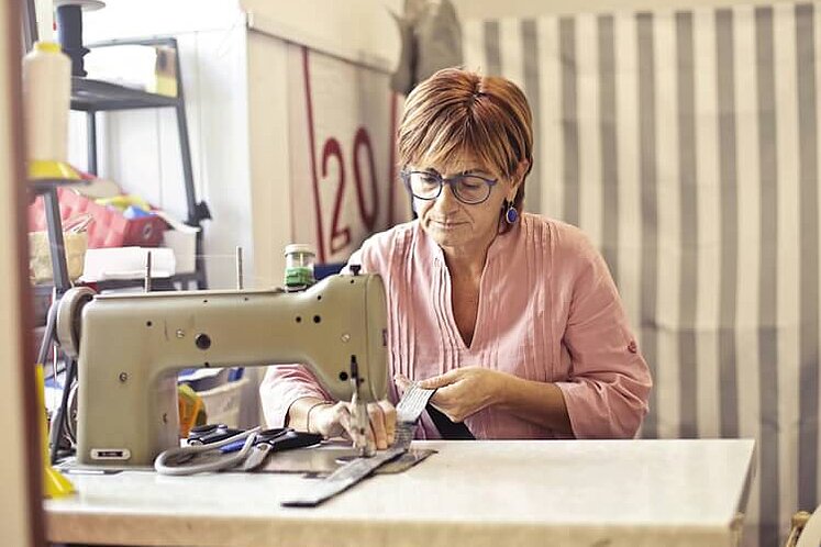 Eine Frau arbeitet in einer Änderungsschneiderei.