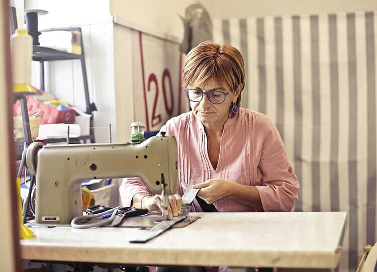 Eine Frau arbeitet in einer Änderungsschneiderei.