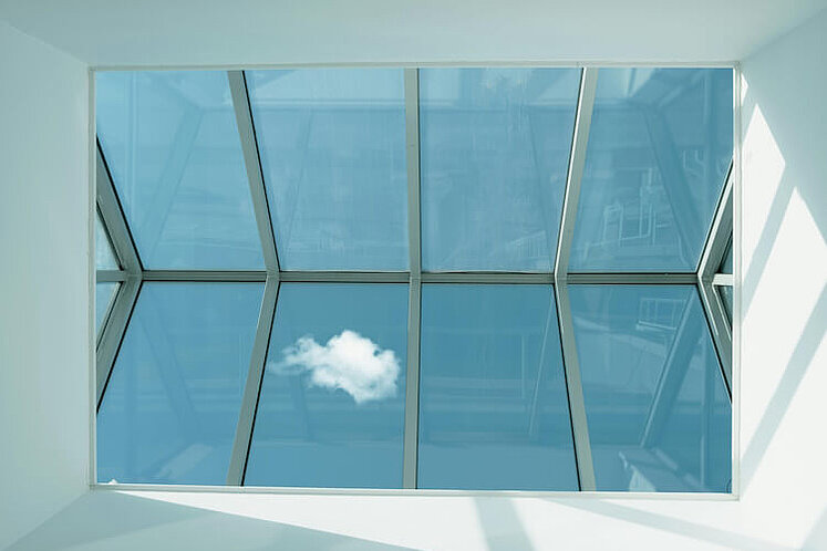 Ein Dachfenster mit Aussicht auf den Himmel.