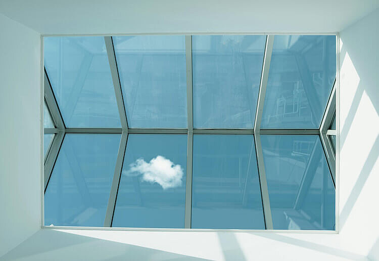 Ein Dachfenster mit Aussicht auf den Himmel.