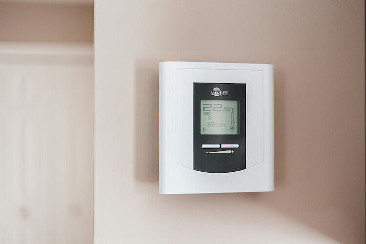 Ein digitales Heizungsthermostat an einer Wand