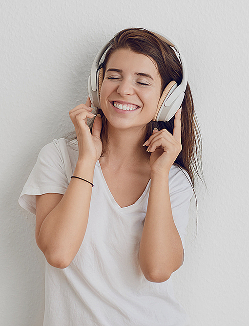 Hübsche junge Frau hört mit Kopfhörern Digitalradio.