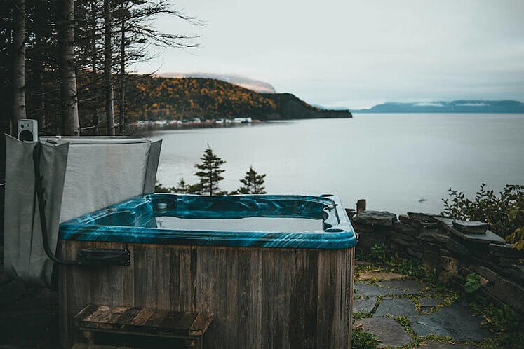 Ein Whirlpool im Garten mit Blick auf einen See.