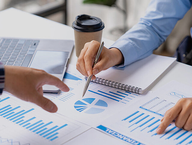 Papiere mit Zahlen und Fakten werden im Business Meeting diskutiert. 