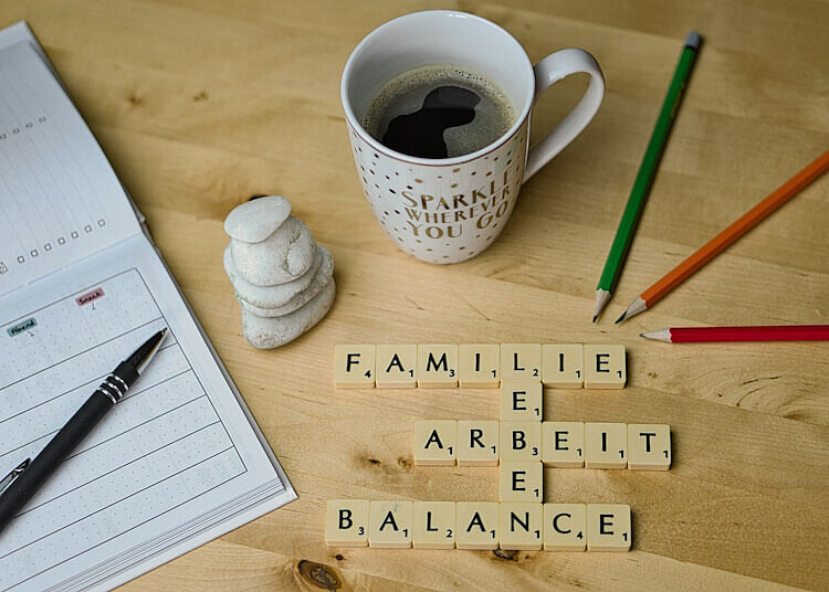 Scrabble-Buchstaben, die die Wörter Familie, Leben, Arbeit und Balance darstellen.