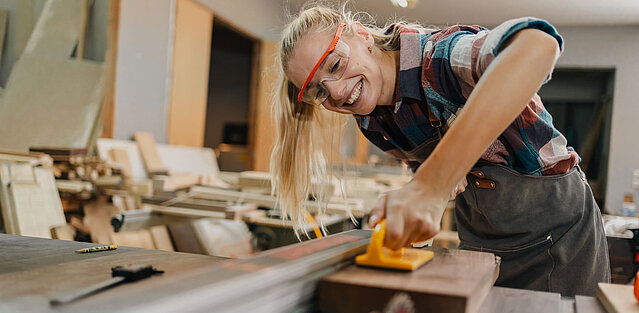 Kreative Tischlerin arbeitet mit Holzwerkzeugen im Tischlereibetrieb